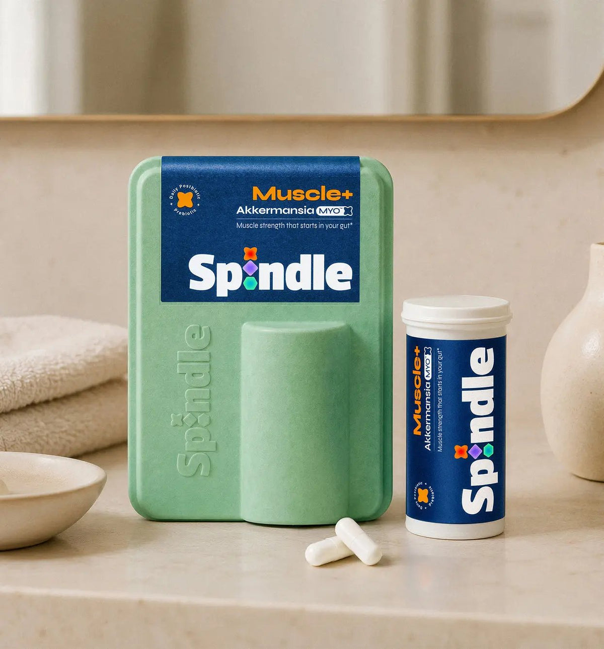 Spindle muscle+ supplement packaging on a bathroom counter with Muscle+ Akkermansia product.