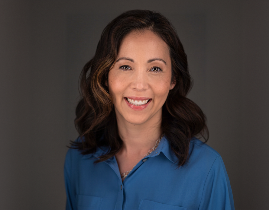 Woman wearing a blue shirt against a dark background
